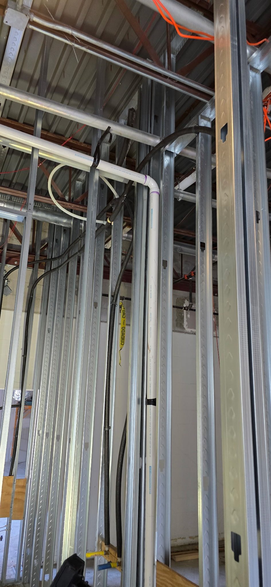 New water supply lines run through metal stud framing at a commercial building under construction