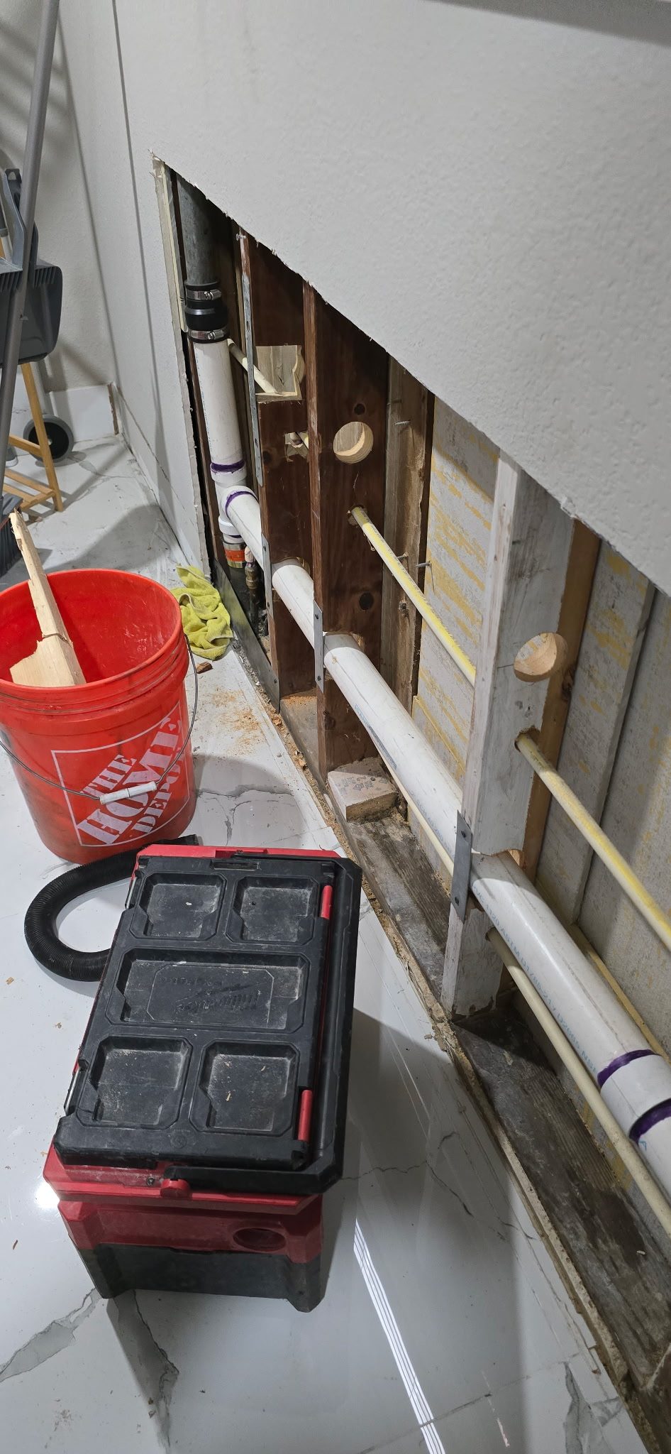 New water and drain lines running through drilled wall studs in a room opened up for a repipe